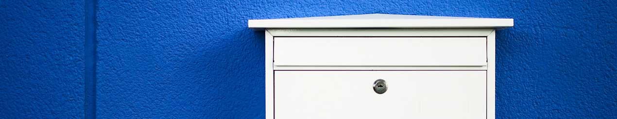 Briefkasten an blauer Hauswand